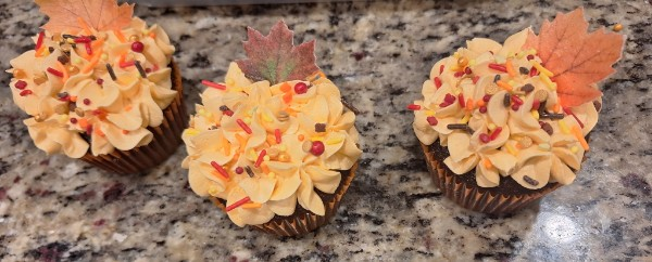 Autumn cupcakes with orange frosting and leaf toppers
